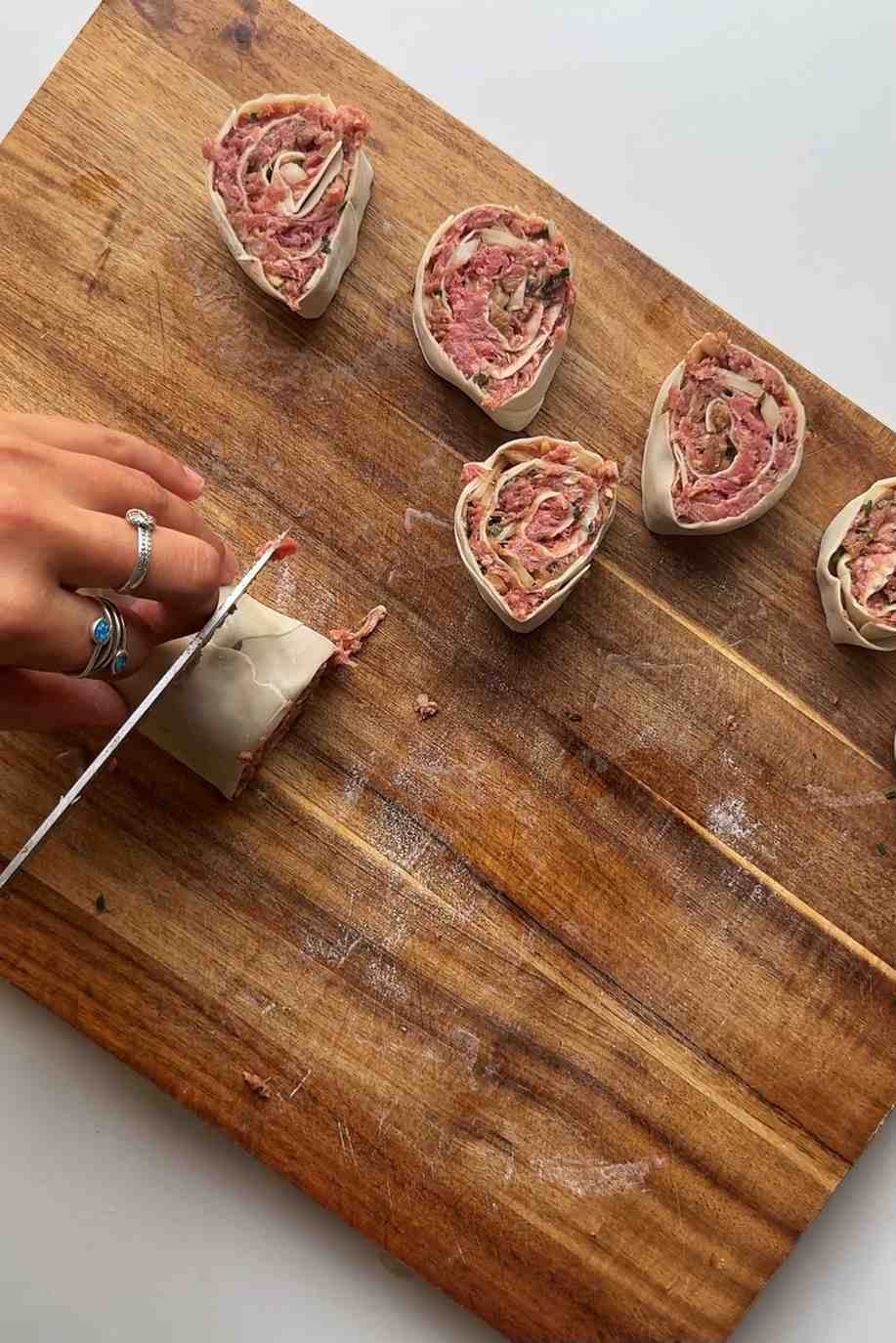 Slicing the dumpling log into little wheels.