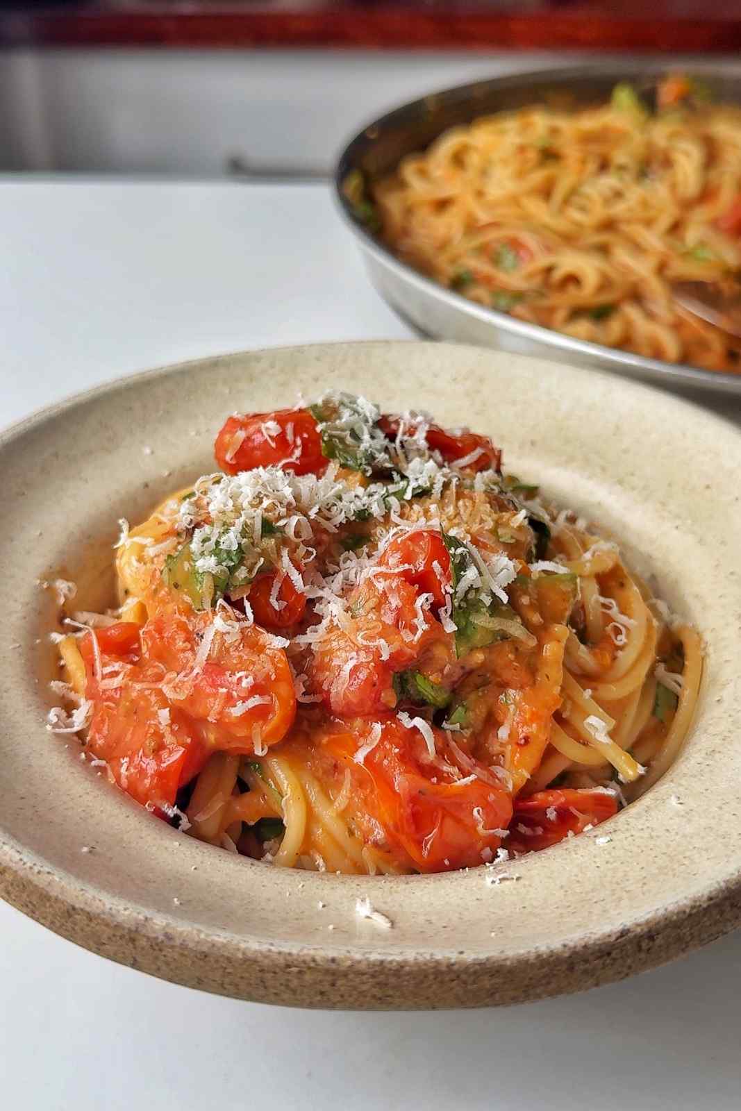 Roasted tomato pasta sauce in a bowl topped with parmesan.
