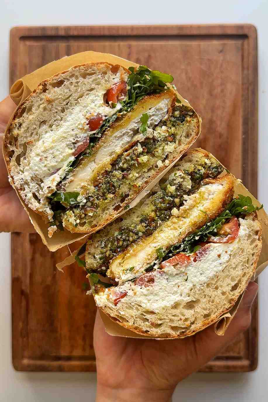 Cross section of a summer's day sandwich with goats cheese, pesto and fried chicken.