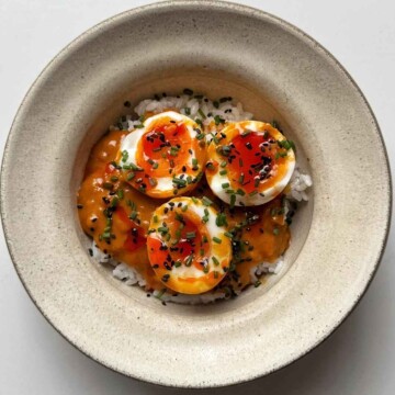white bowl filled with rice and topped with peanut gochujang chili eggs.