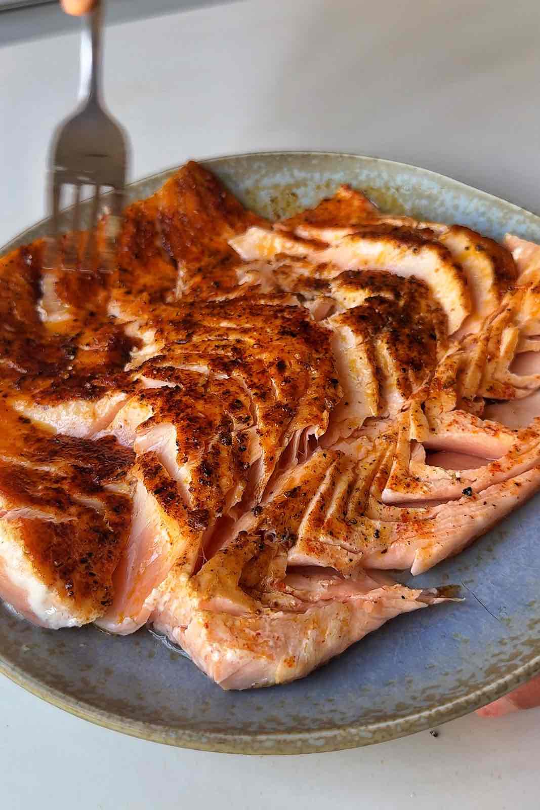 Breaking salmon apart using the back of a fork.