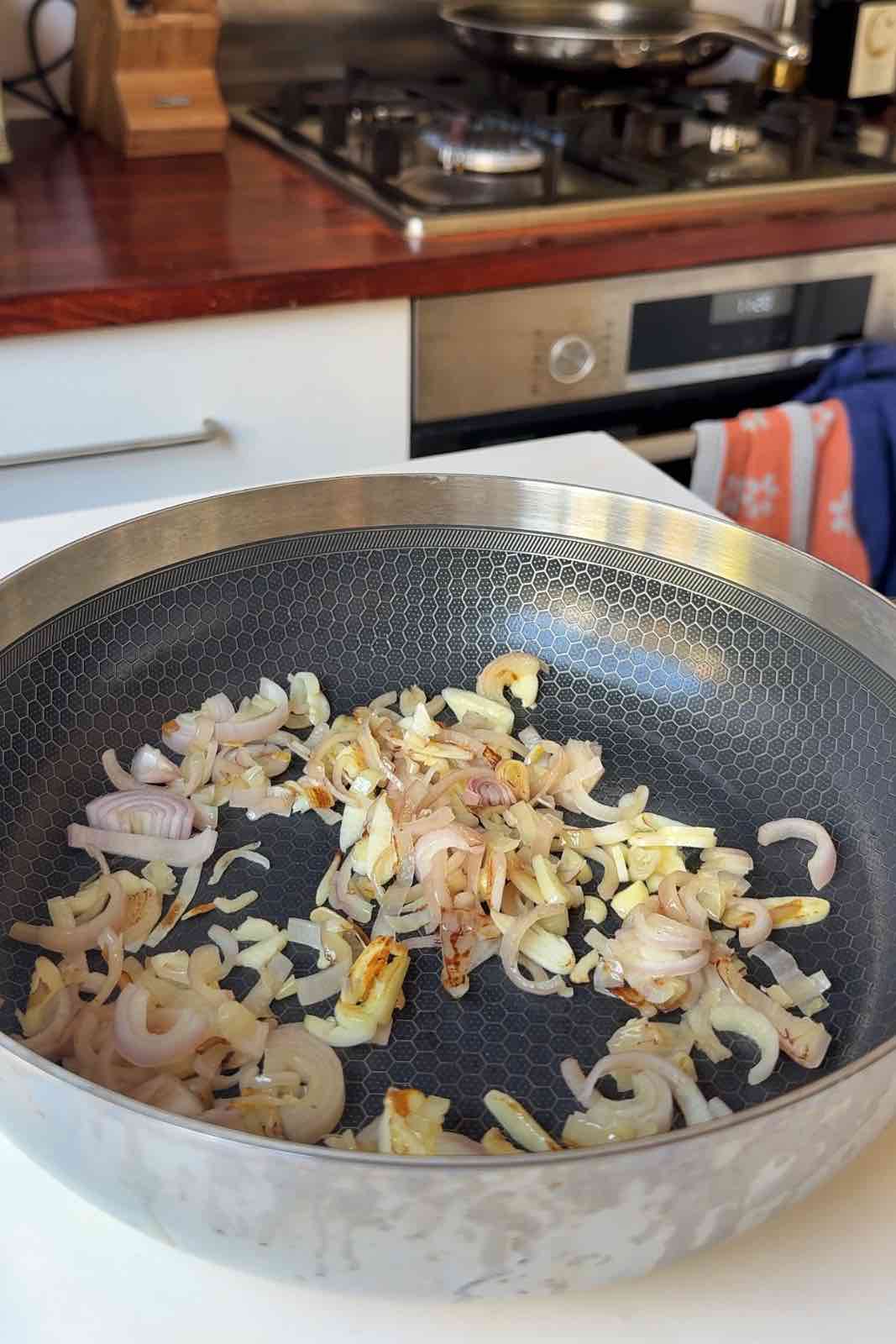 Frying shallots and garlic in a pan.