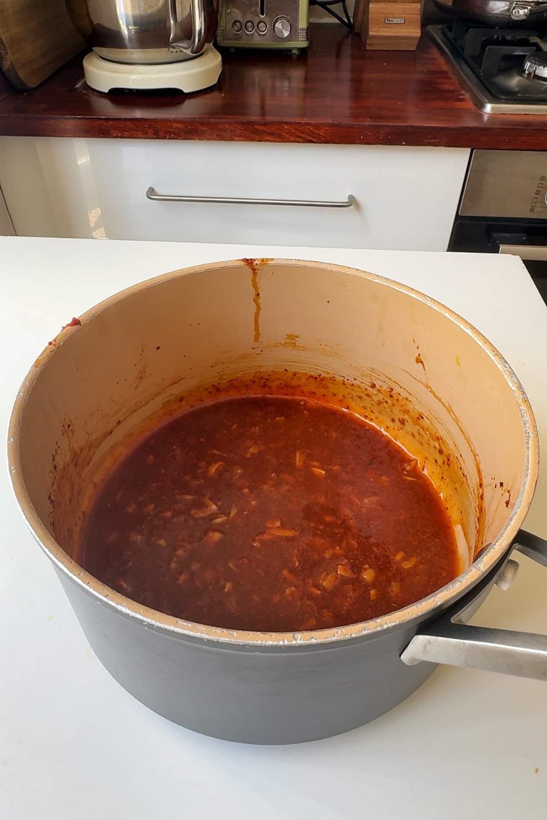 A sticky orange sauce in a saucepan.