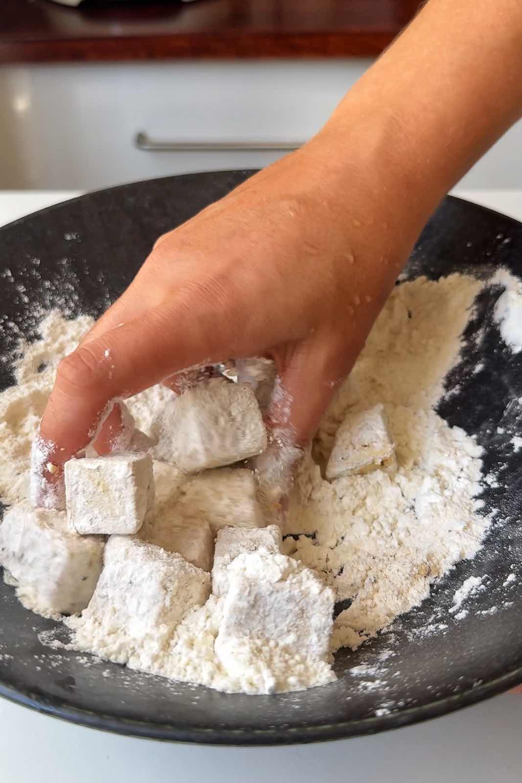Tossing the tofu in the cornstarch.