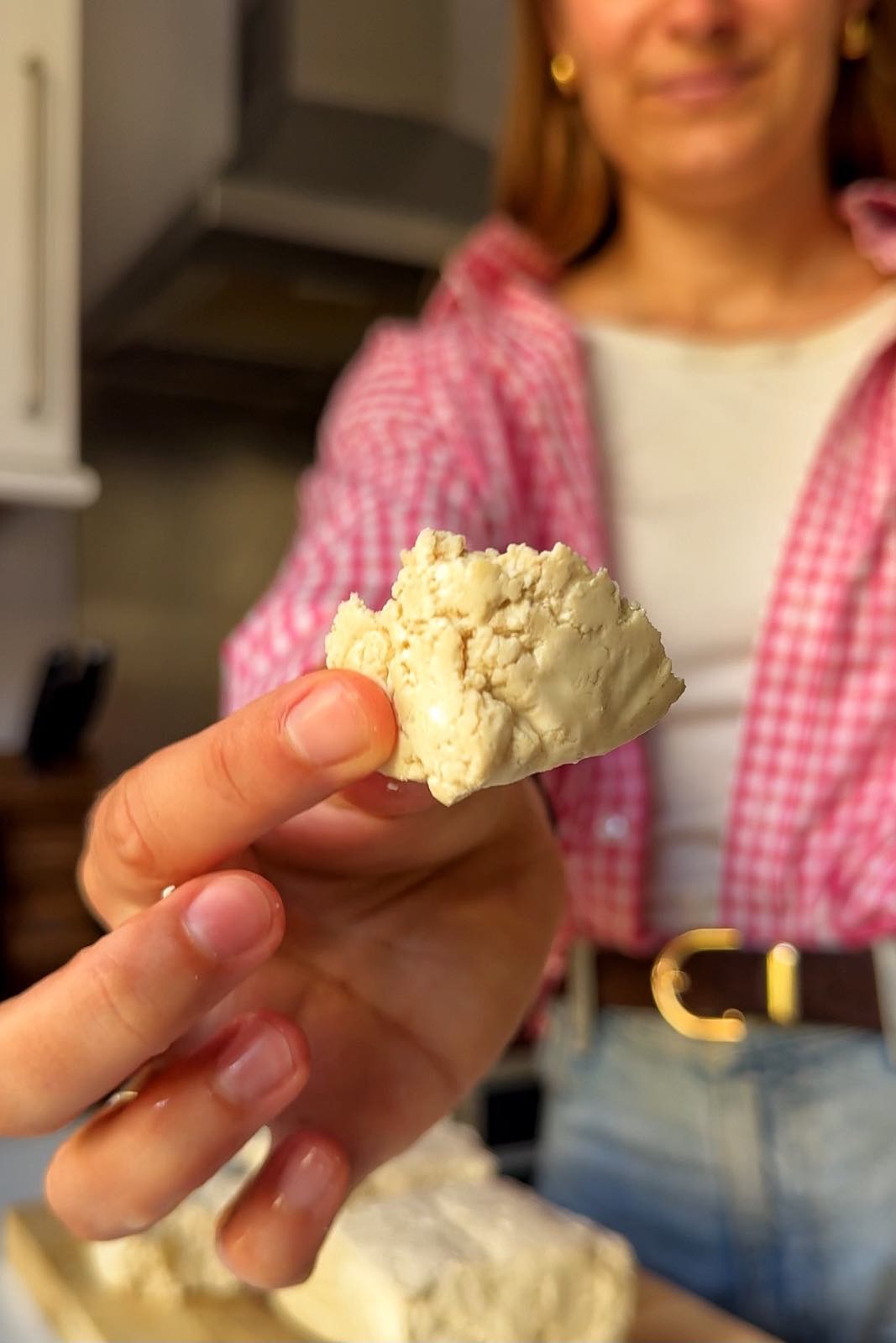 Torn tofu being held up to the camera.