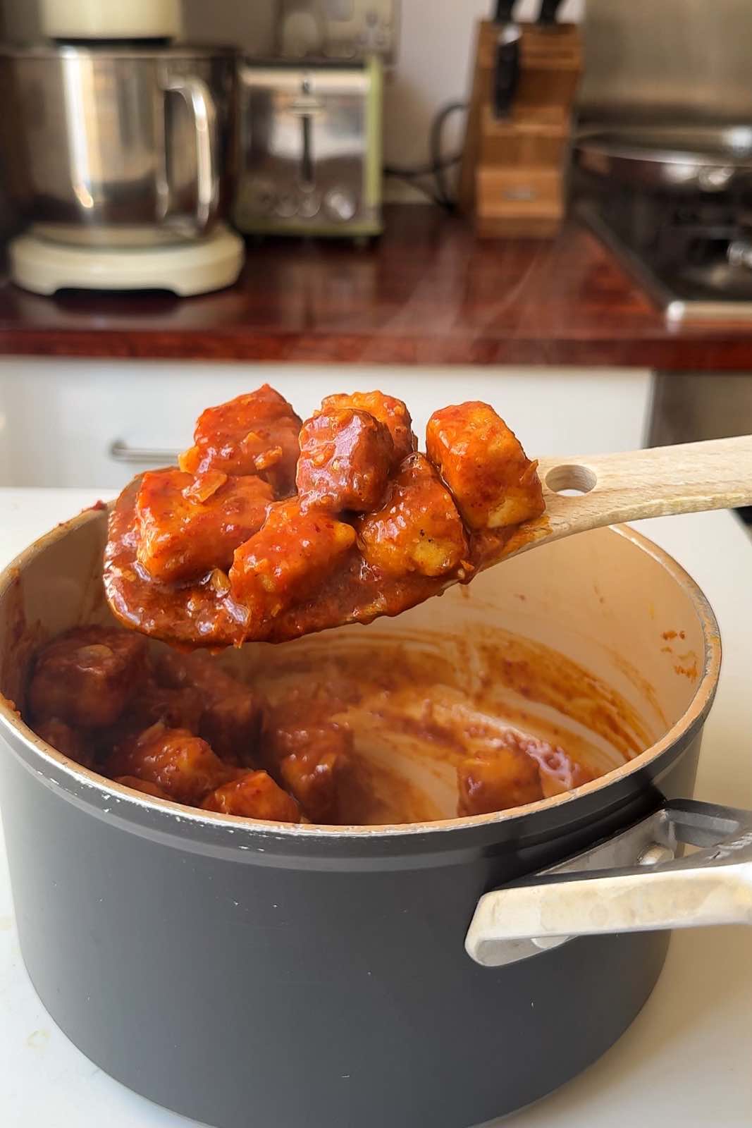 Extra firm tofu stirred into the sticky orange tofu sauce.