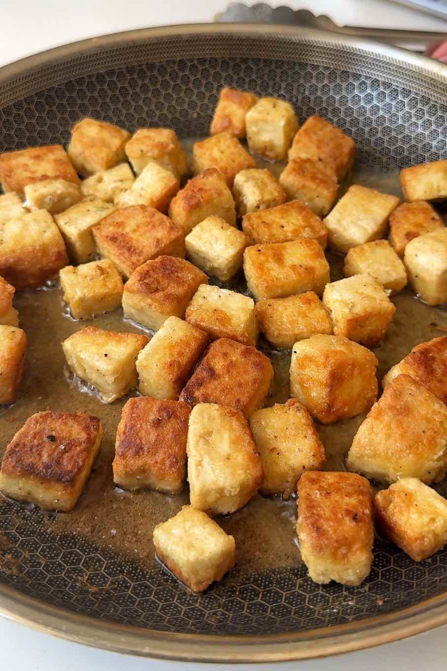 Frying tofu in a pan.