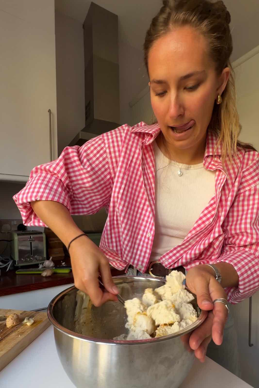 Stirring the extra firm tofu in a bowl with the marinade.