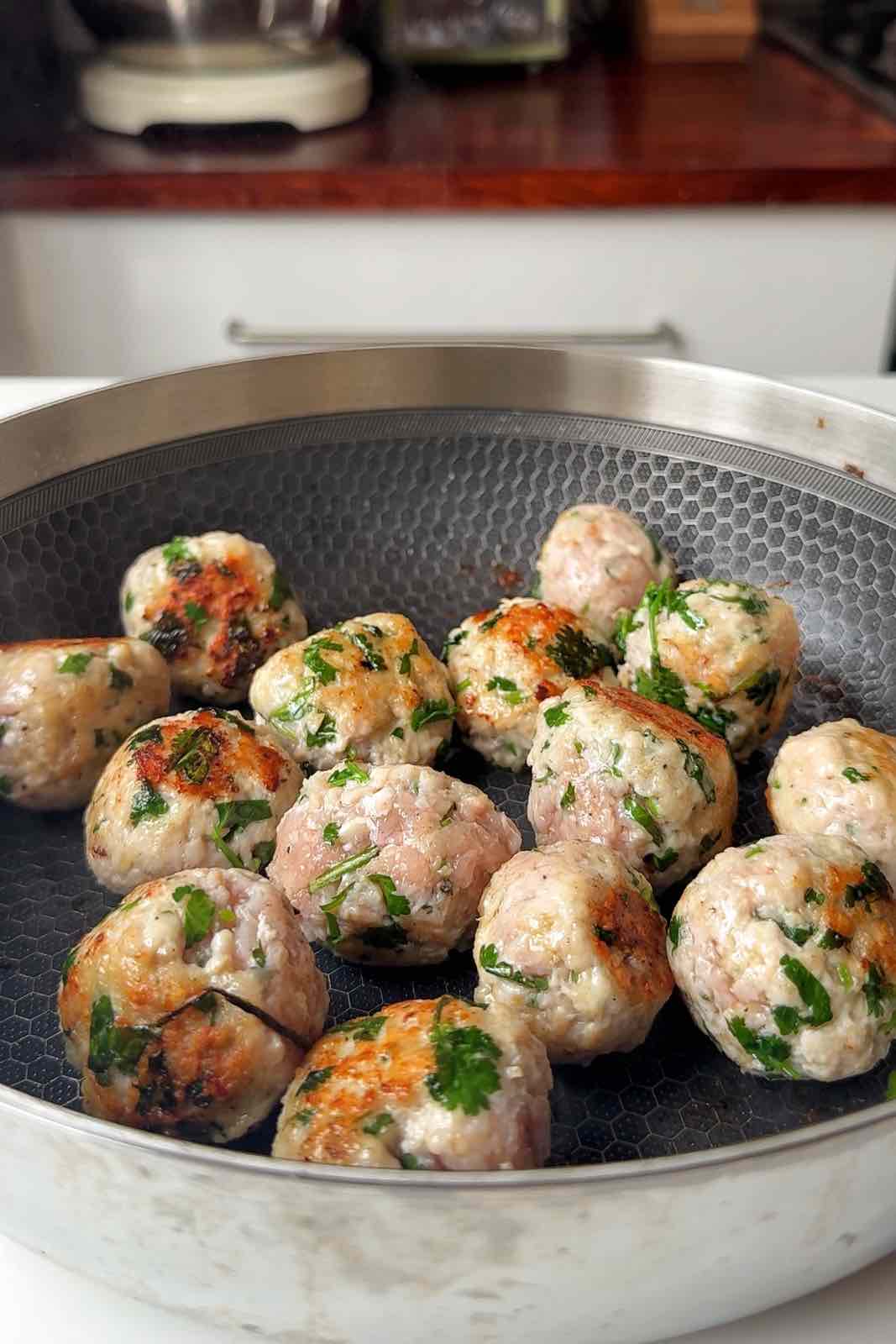 Frying Thai chicken meatballs in a pan.