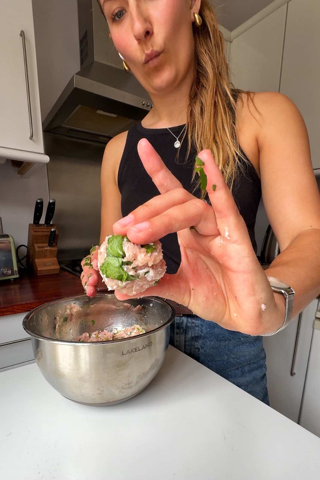 Emily Roz holding meatball up to camera.