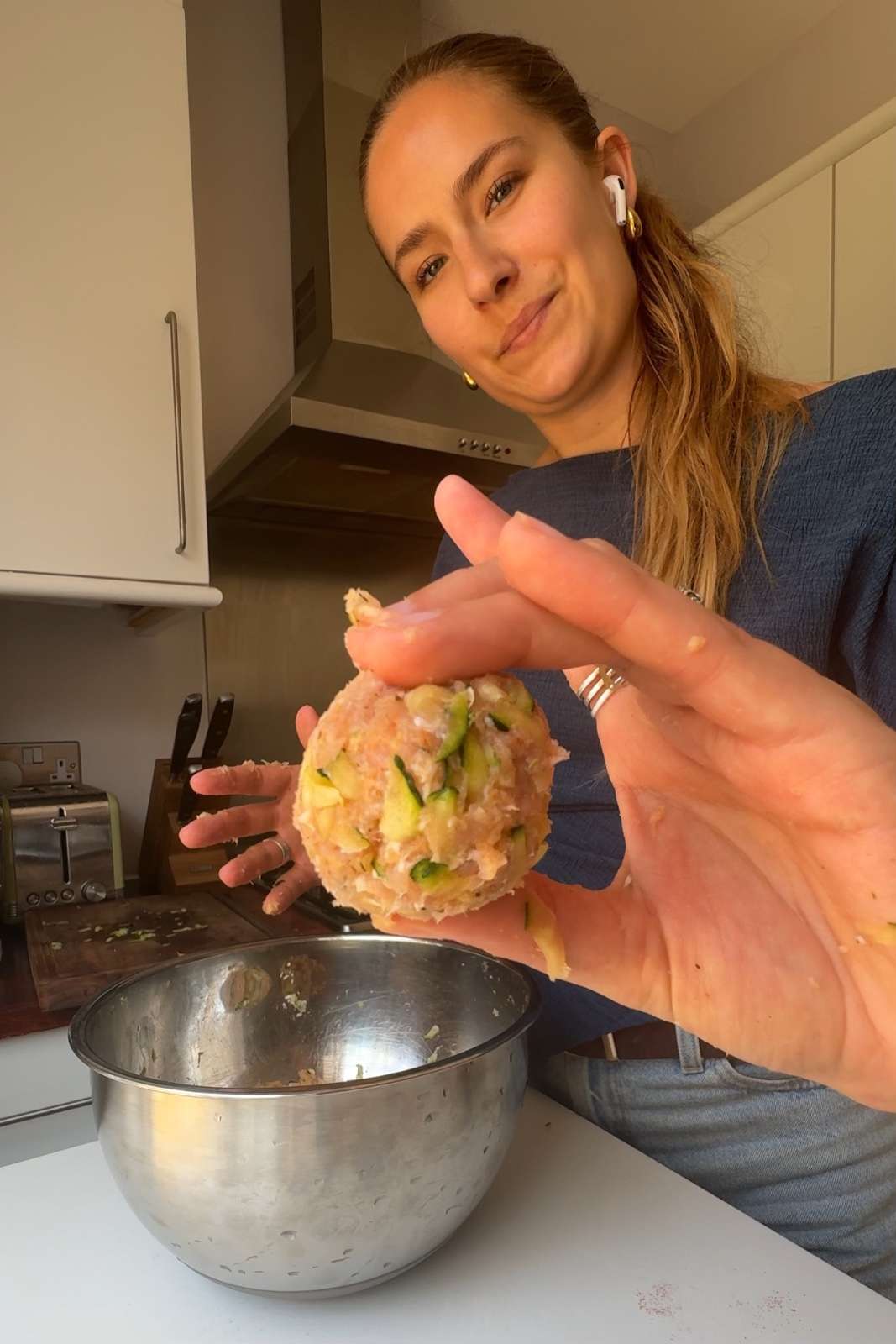 Holding zucchini meatball up to the camera.