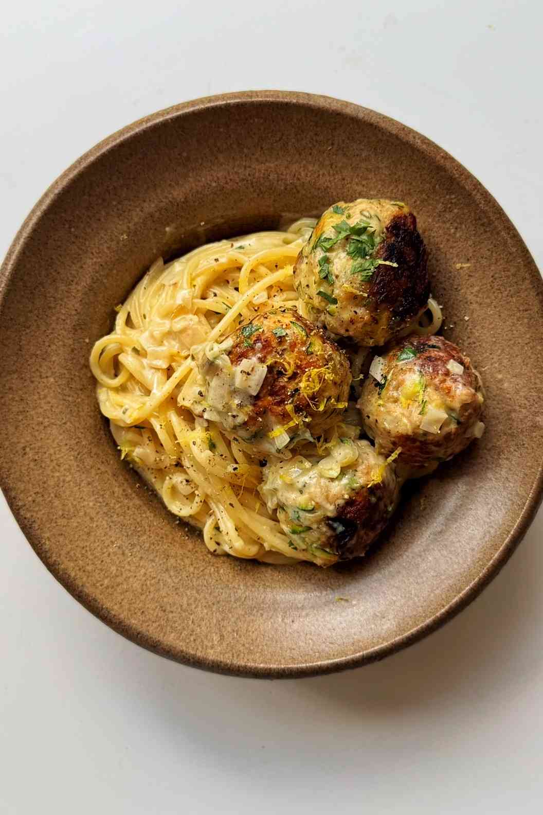Zucchini meatballs in a brown bowl.