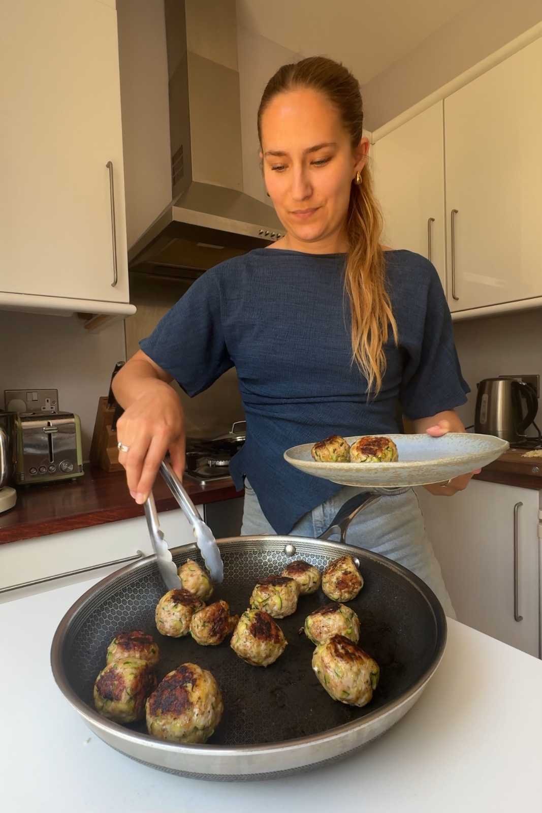 Frying meatballs in a pan.