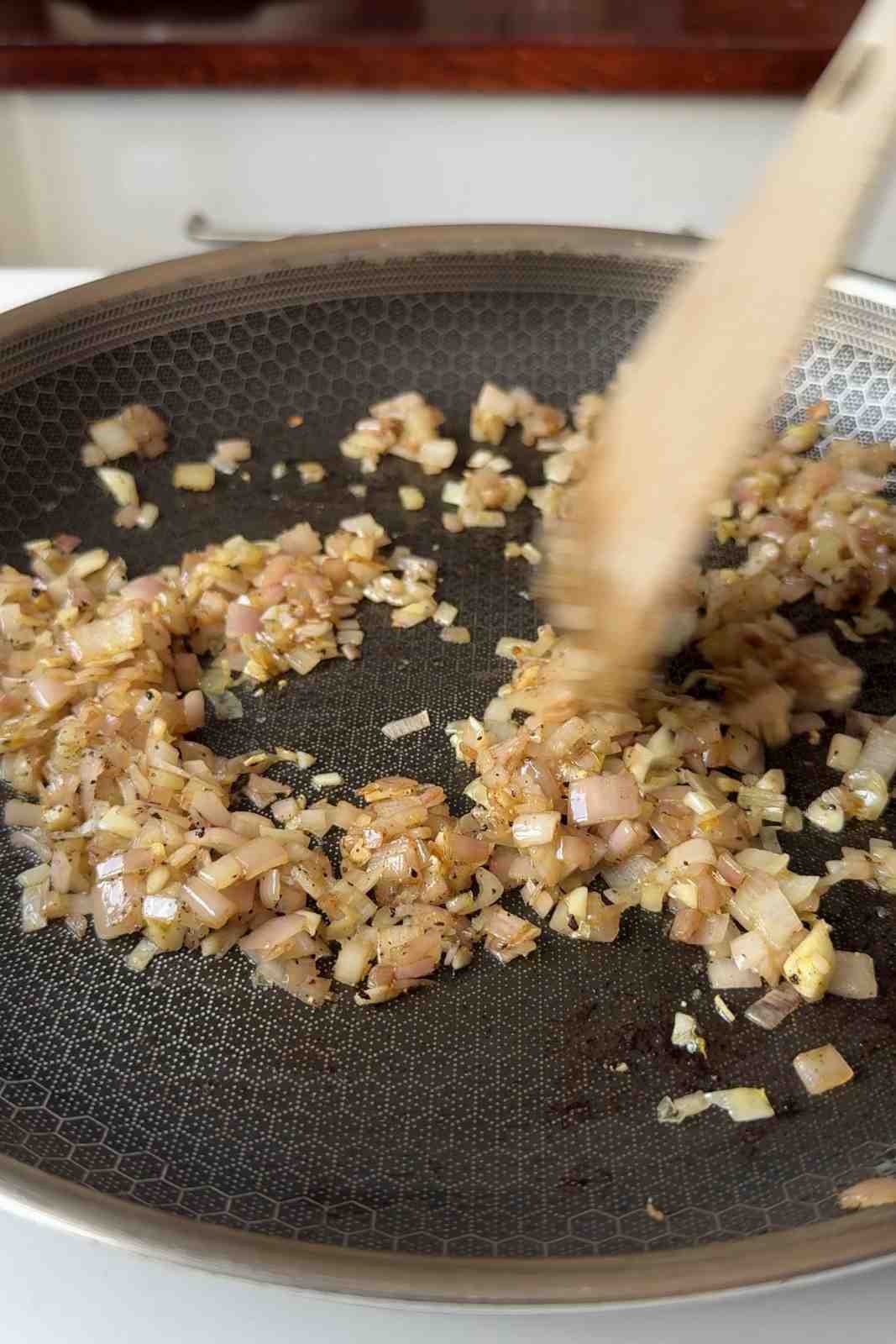 Frying off shallots and garlic in a pan.