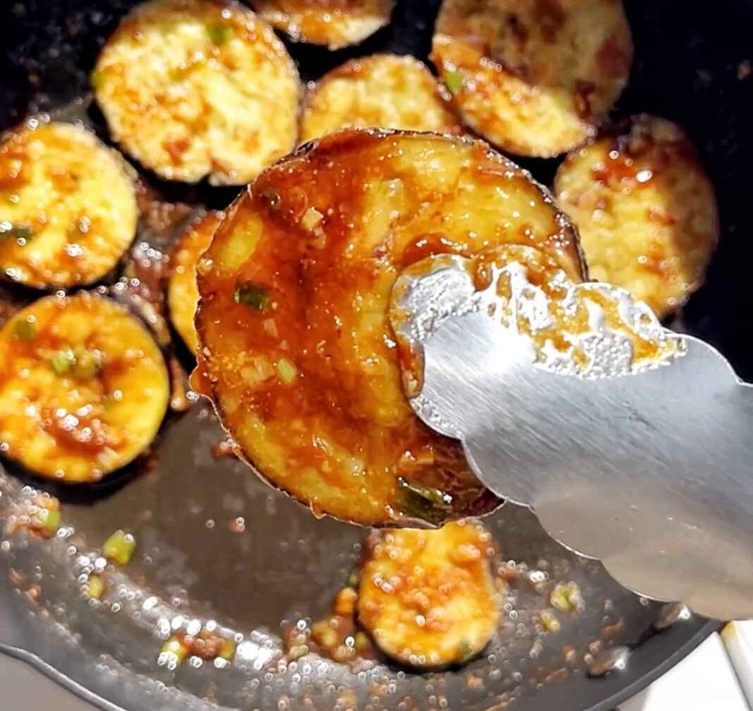 Sticky miso glazed eggplant being fried in a pan. 