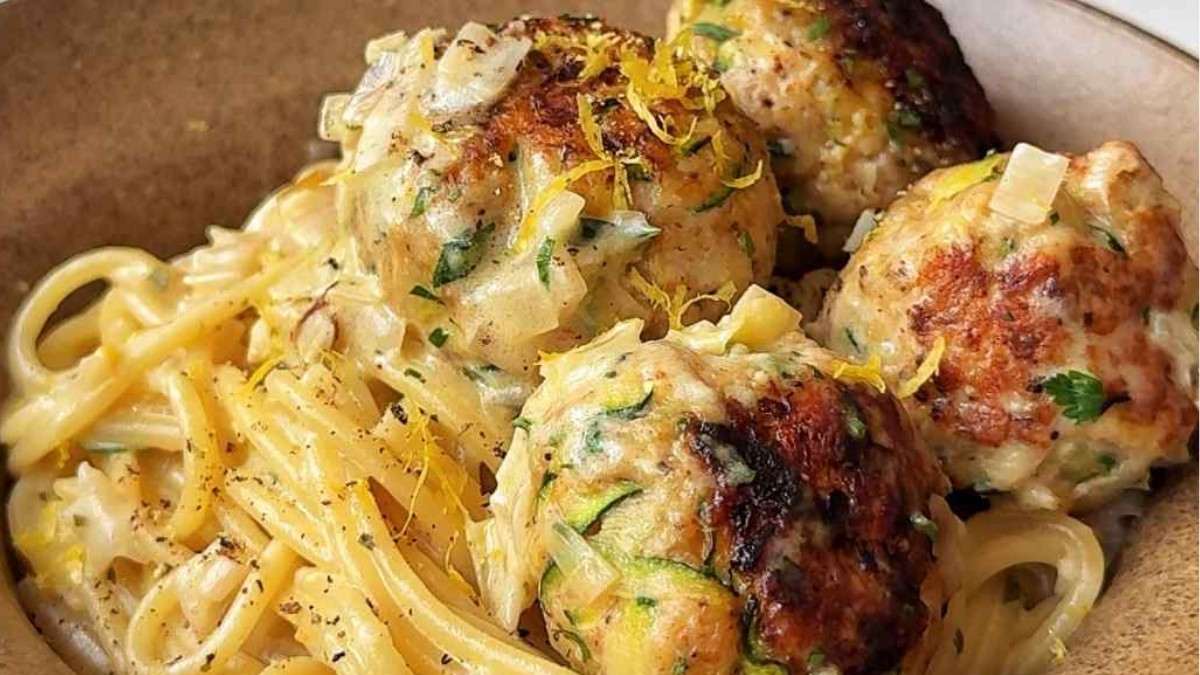 Spaghetti with zucchini chicken meatballs in a creamy Boursin sauce in a brown bowl.
