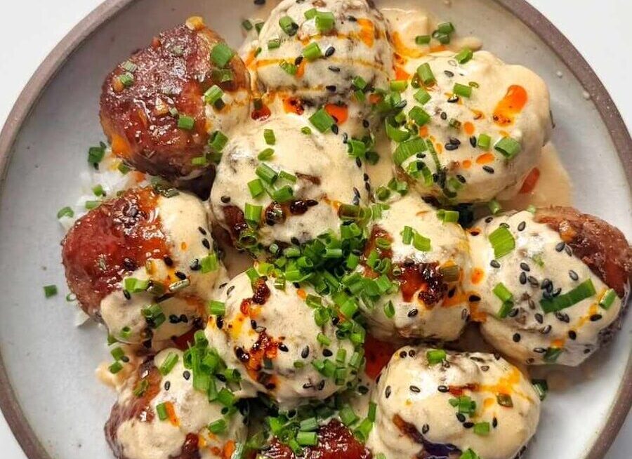 Bowl of teriyaki meatballs with spicy miso sauce, rice and chives.