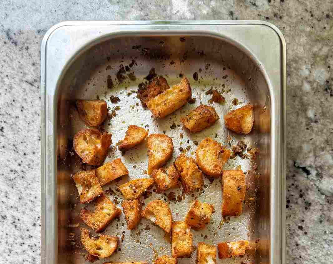 Homemade ciabatta croutons in a silver baking tray.