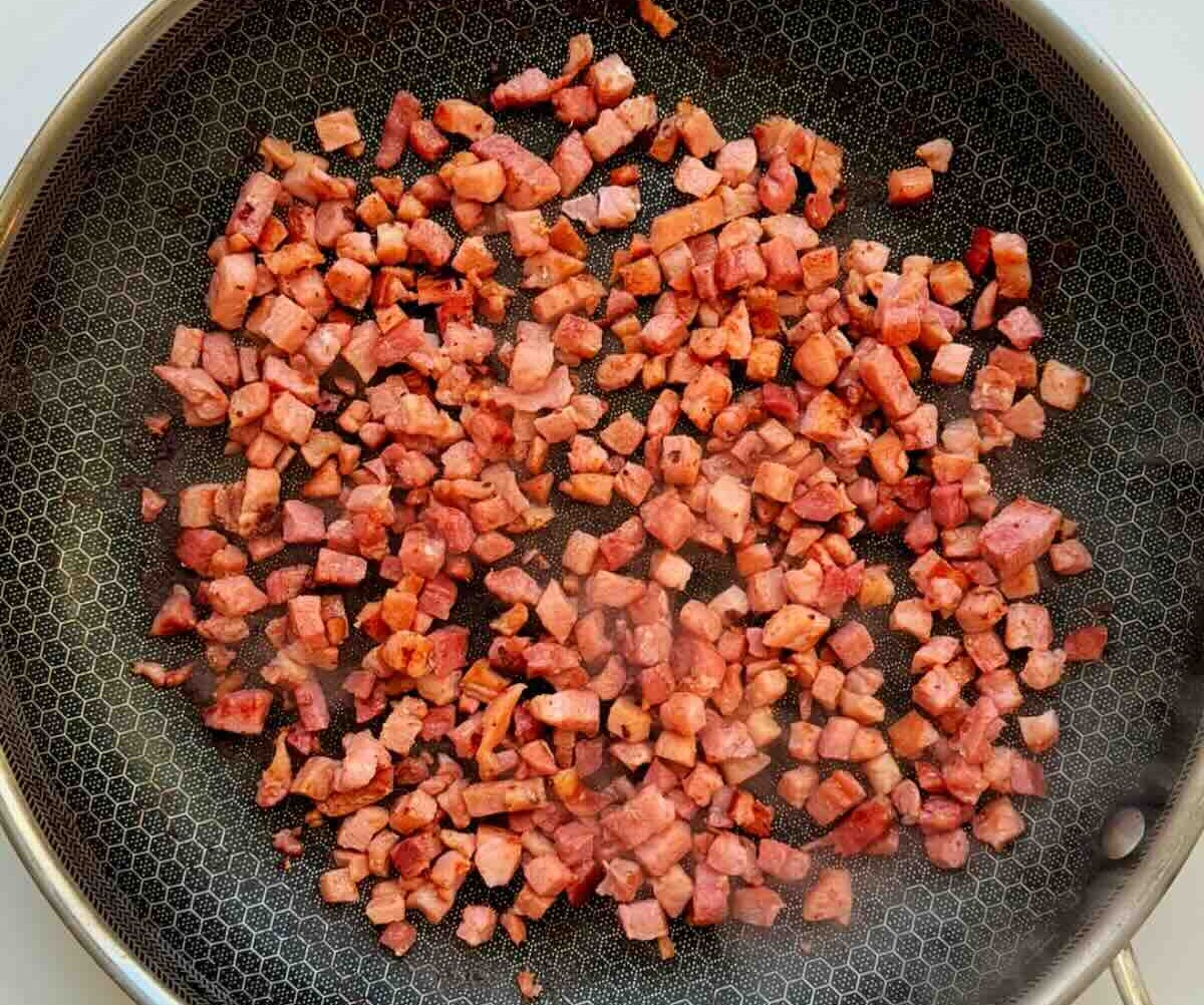 A pan full of cooked bacon bits.