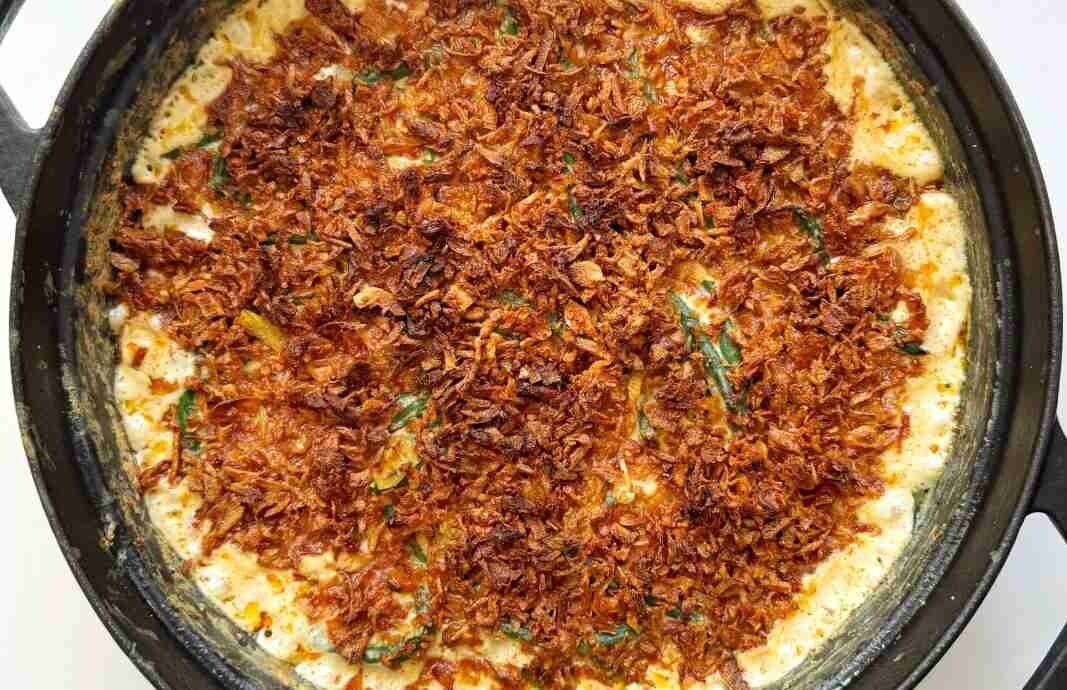 Crispy fried onions on top of a creamy green bean casserole.