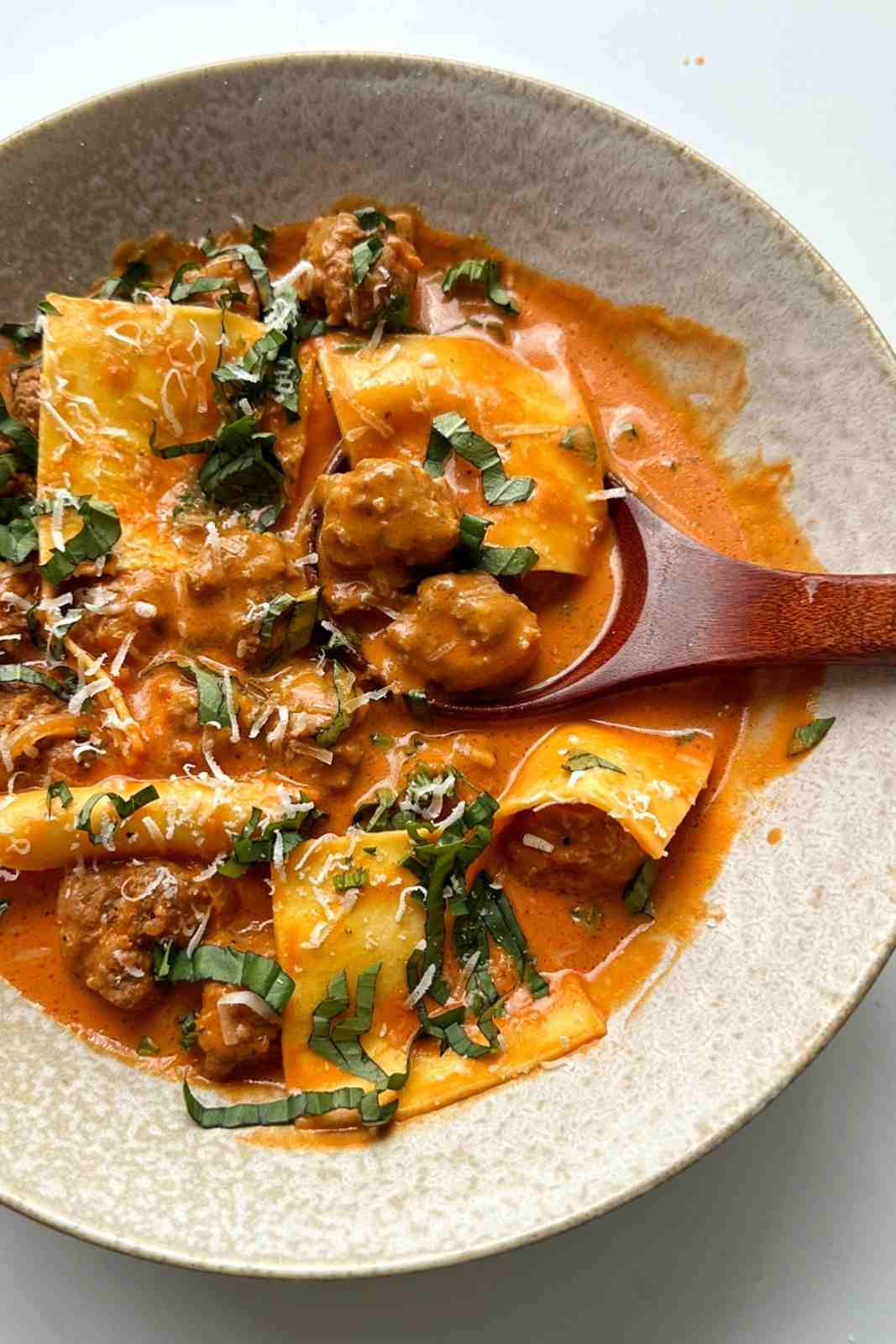 Grated parmesan on top of a bowl of deconstructed ravioli soup.