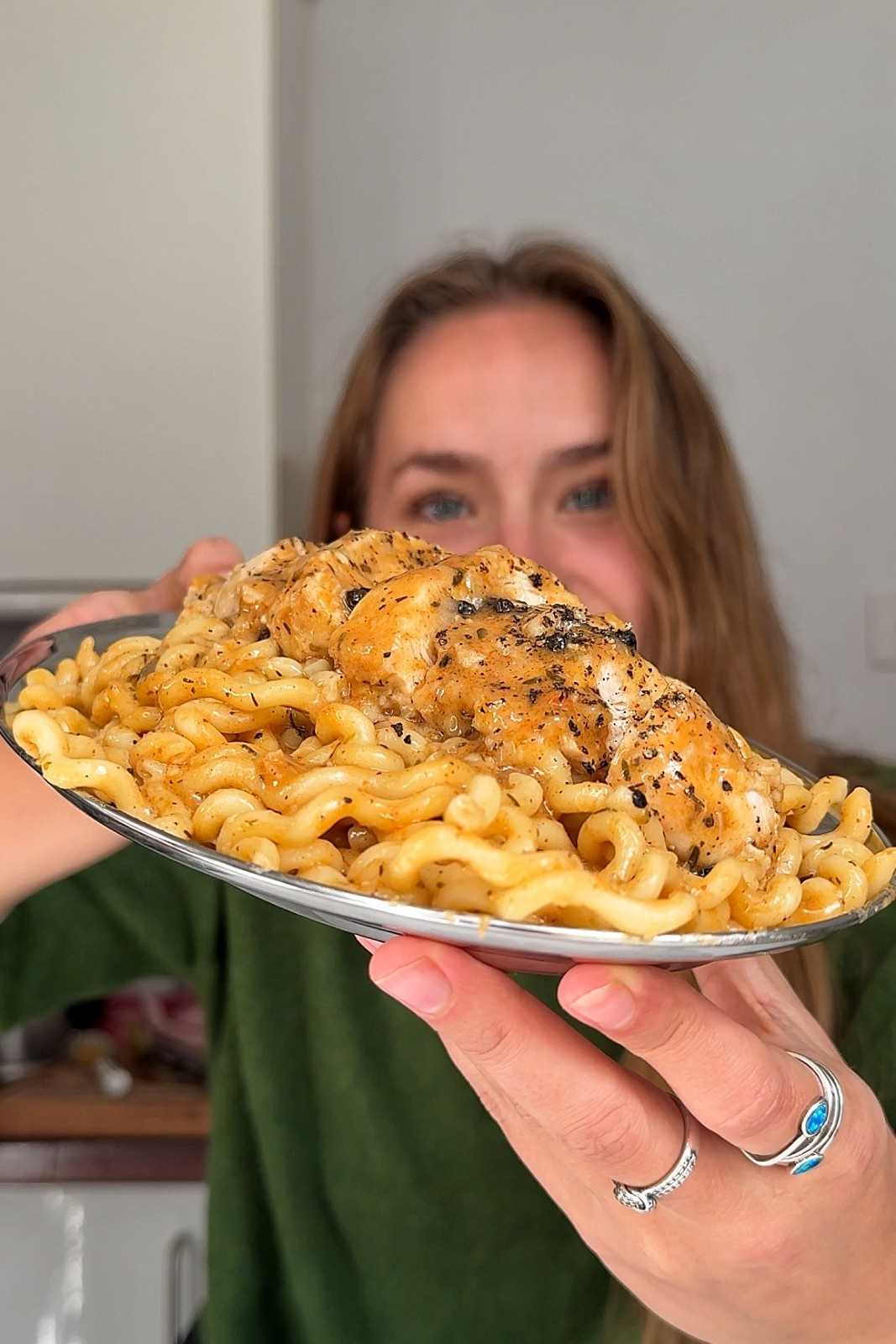 Emily holding a plate of chicken au poivre pasta.