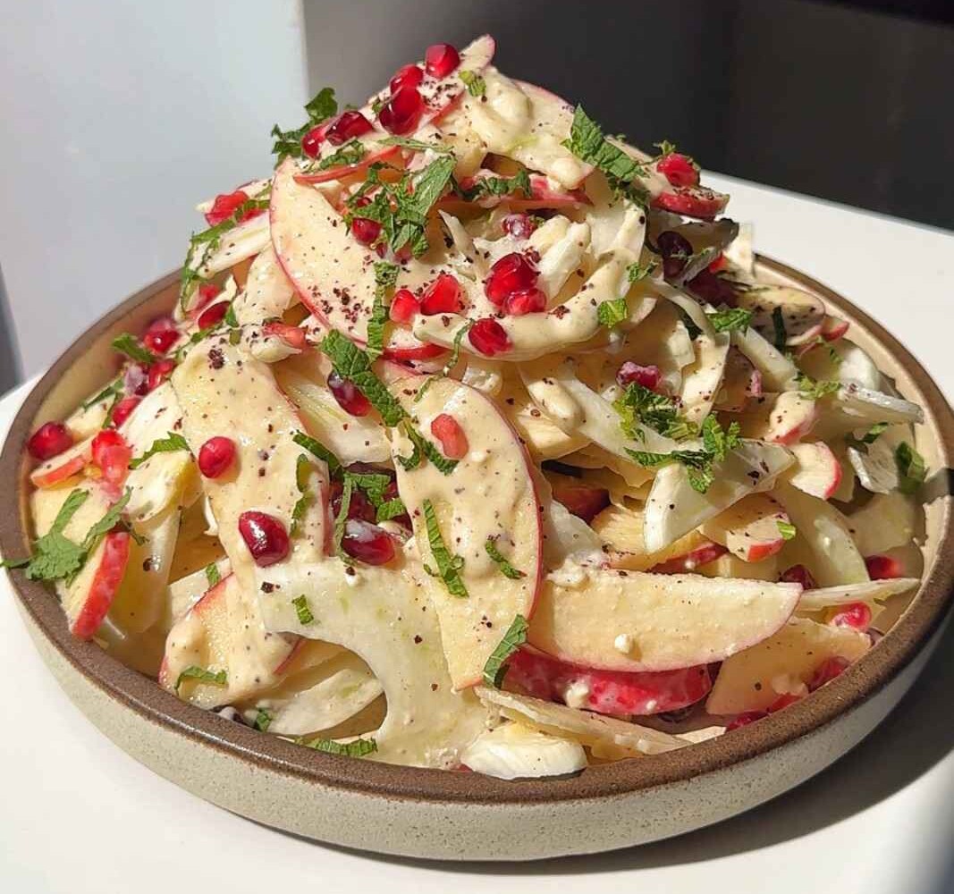 Apple fennel salad with pomegranate seeds and a creamy blue cheese tahini dressing.