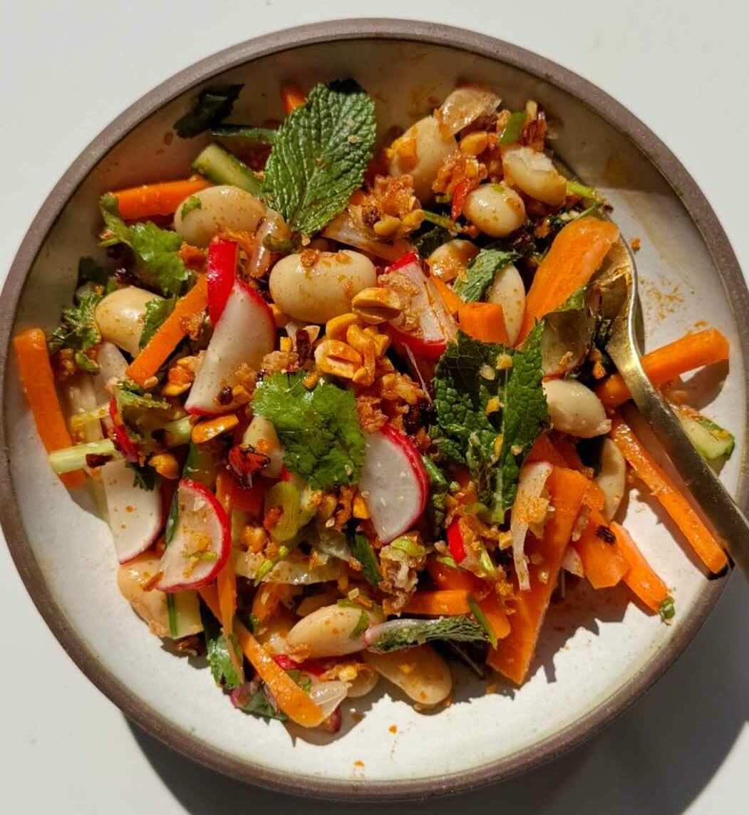 Butter bean salad with loads of fresh herbs, crunchy veggies, crushed peanuts and a spicy nuoc cham-style dressing with lime and fish sauce.