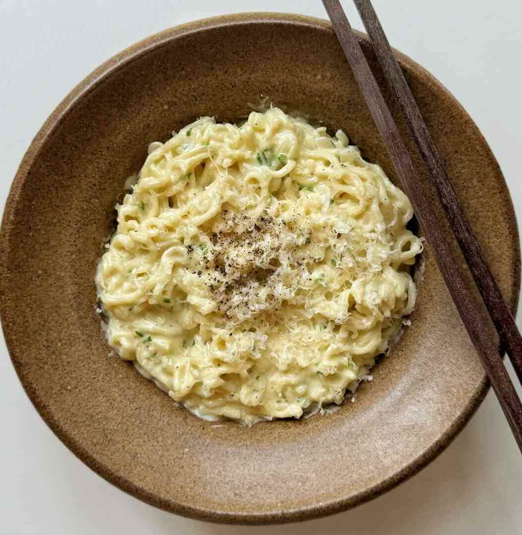 Creamy Garlic Parmesan Noodles in a stone bowl, finished with some parmesan.