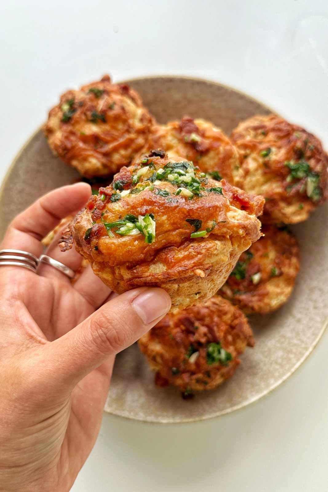 Emily Roz holding a cheese and bacon muffin.